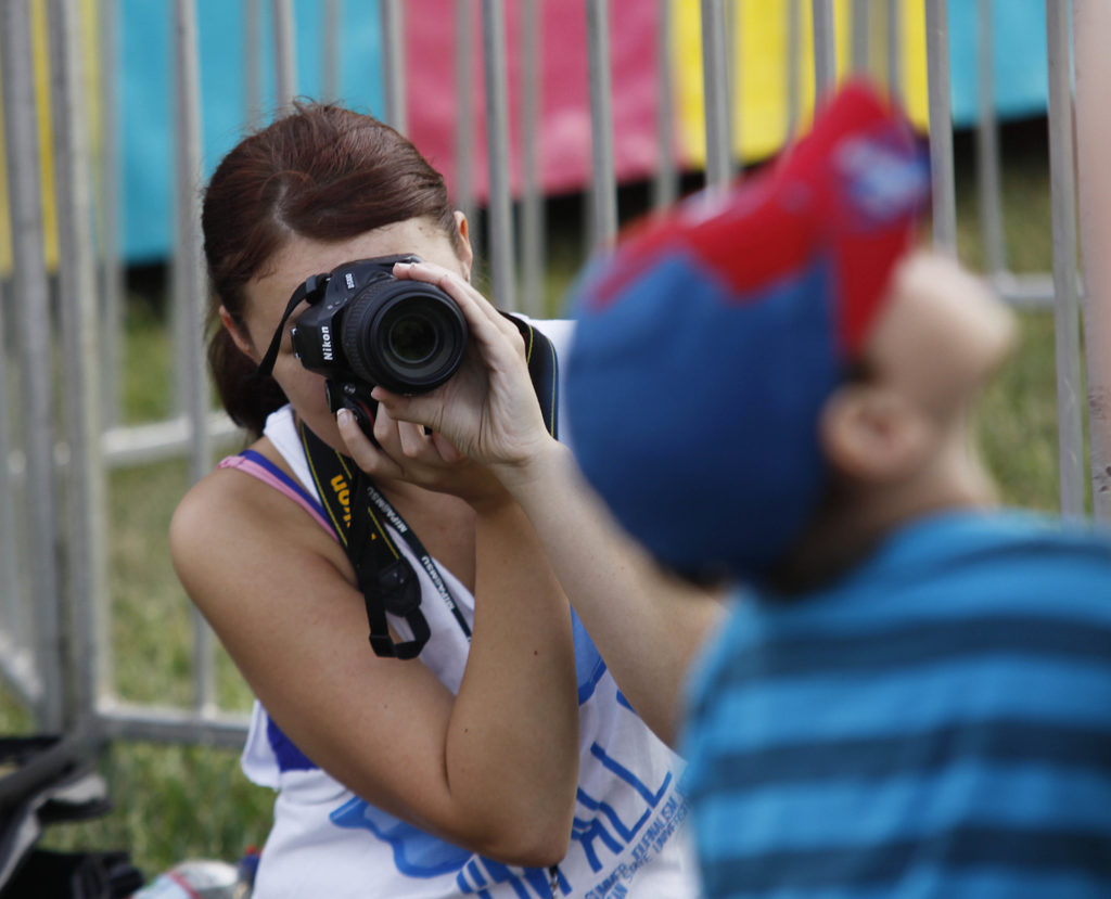A student focuses in on her subject while completing their location shoot assignment.