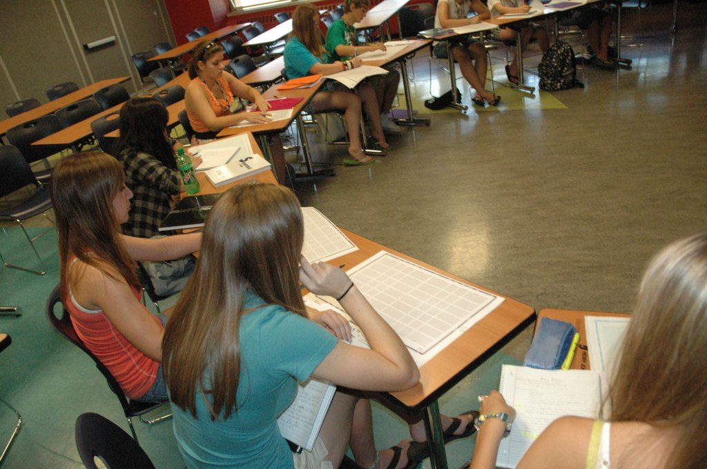 Yearbook students sit in a circle in their desks at the summer workshop.