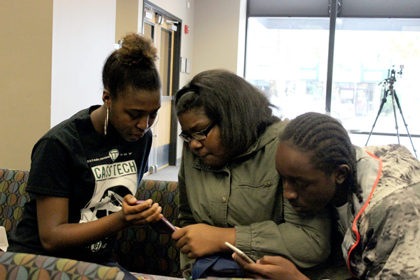 Cass Tech High School senior Kaelyn Collins shows students from her school the Facebook Live segment she did during Crain MSU Detroit High School Journalism's Training Day event.