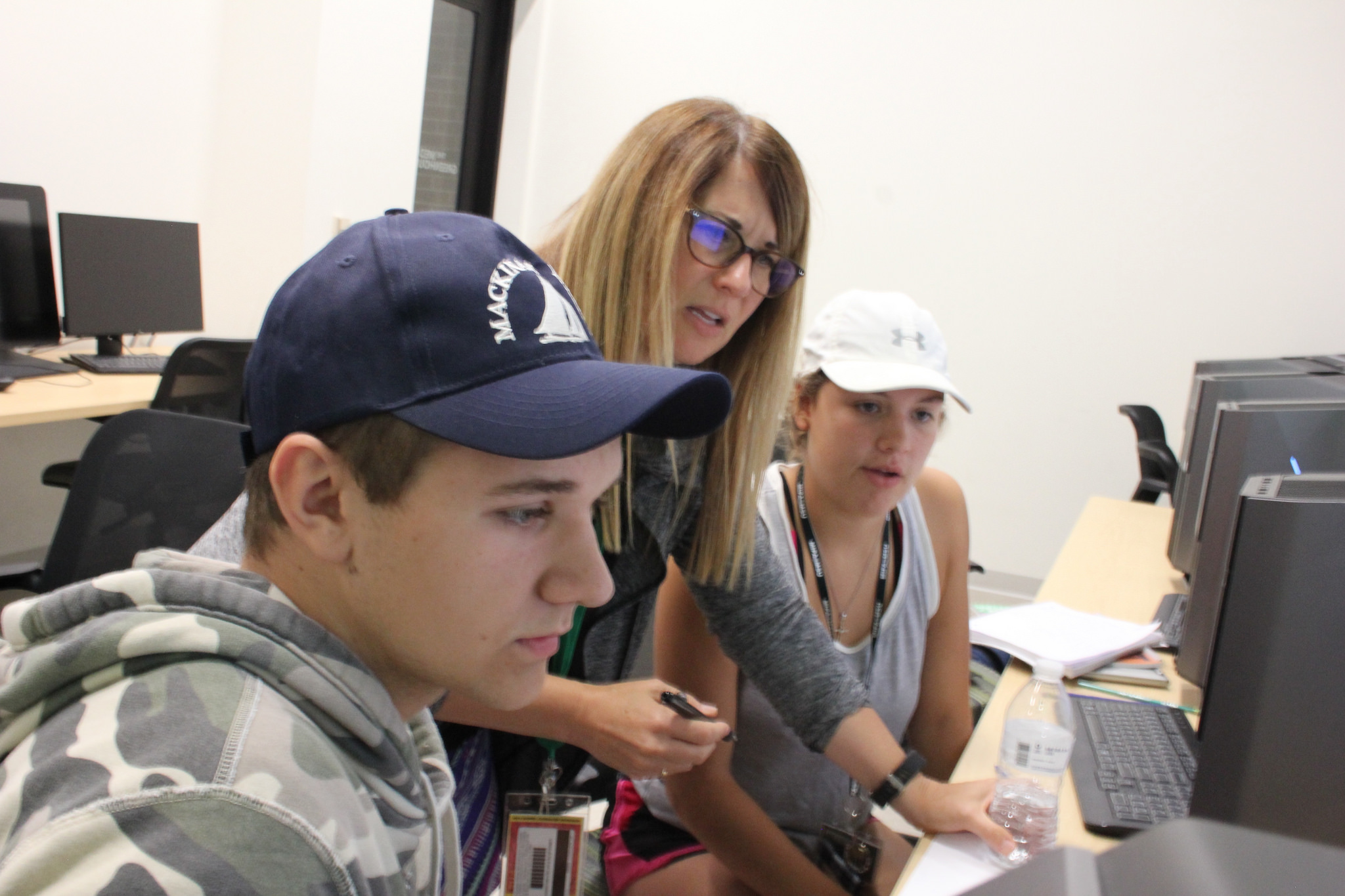 Instructor Ava Butzu helps students at the MIPA Summer Journalism Workshop