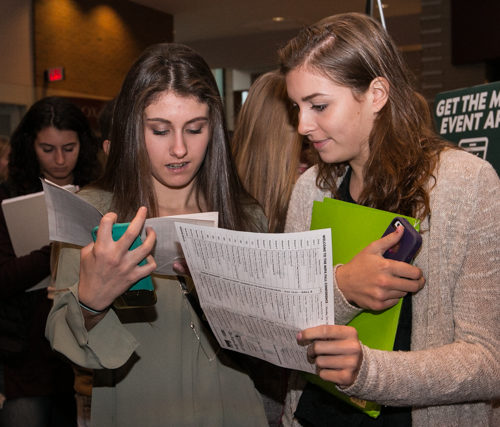 Students look over the paper schedule at the MIPA fall conference.